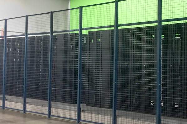 A secure caged area within a data center, featuring a row of server racks.