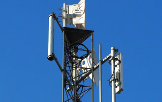 Communication tower with multiple antennas and satellite dishes.