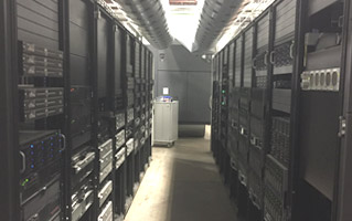 Narrow aisle between server racks in a data center.