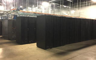 Multiple rows of server racks in a well-lit data center.